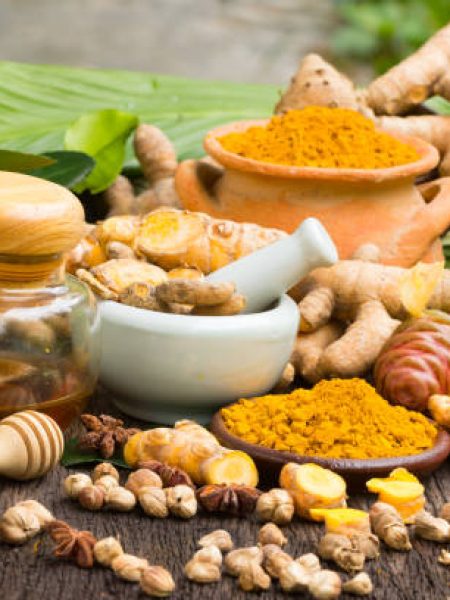 Turmeric powder,Turmeric in Mortar Grinder drugs and ingredient herbs on wooden background